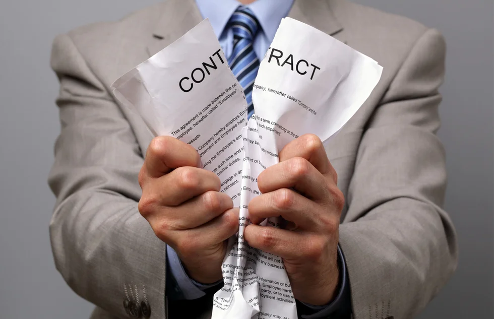 Man tearing up a contract — breach of contract in Ontario